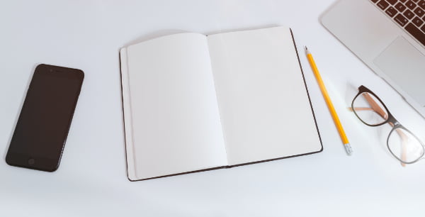 open blank book with pencil and glasses