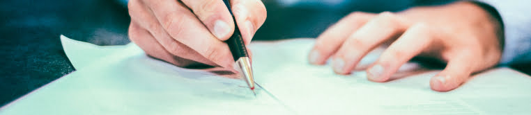 Person filling out documents with a pencil