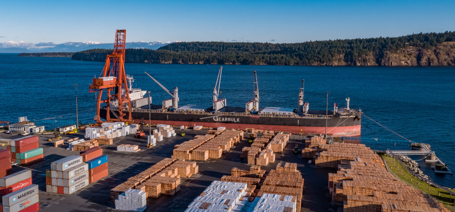 Cargo ship docked at Nanaimo terminal with an island in the background