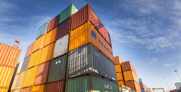 Low angle shot of shipping containers on a bright blue clouded day